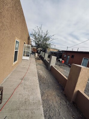 A narrow concrete pathway flanked by walls, leading to a building with a window and a door. - Cozy 2-bedroom apartment cheaper than a hotel with AC in charming Presidio (Presidio)