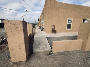 A narrow alleyway with a concrete path flanked by buildings with beige walls and a window. - Cozy 2-bedroom apartment cheaper than a hotel with AC in charming Presidio (Presidio)