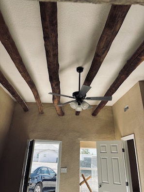 A room with a ceiling fan, wooden beams, a door, and a view of a car through an open door. - Cozy 2-bedroom apartment cheaper than a hotel with AC in charming Presidio (Presidio)