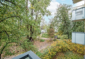 A garden area with trees, a pathway, and a signboard. - Olszowa 14 Riverside Apartment (Warszawa)