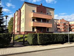 Ein mehrgeschossiges Wohngebäude mit Backsteinfassade, Balkonen und einem verschlossenen Eingang.