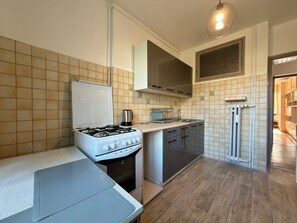 Eine kompakte Küche mit Gasherd, Backofen und kleiner Arbeitsfläche.