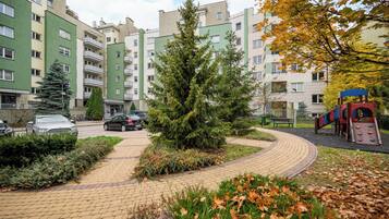 Ein Wohngebiet mit Mehrfamilienhäusern, einem gepflasterten Weg und einem Spielplatz.