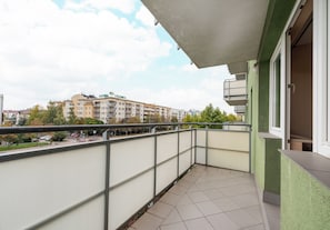 Ein Balkon mit Blick auf ein mehrgeschossiges Gebäude im Hintergrund.