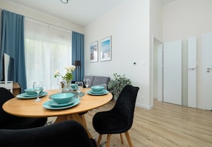 Ein Essbereich mit einem runden Holztisch, blauen Tellern und Stühlen.