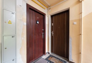 A hallway with two wooden doors, each marked with a number. - Osiedle na Stoku Comfort Studio (Kraków)