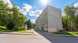 A multi-story building with a flat facade, a small adjacent structure, and a clear sky. - Osiedle na Stoku Comfort Studio (Kraków)