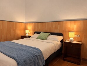 A bedroom with a bed, two bedside tables, and a nightstand with a lamp. - New Listing (Puerto del Rosario)