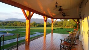 A covered porch with wooden beams, a pool, and chairs. - East Barn Suite at Hubbell Homestaead - Mountain Views & Jetted Tub (Bennington)