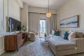 A modern living room with a sofa, a coffee table, a TV, and a painting on the wall. - 2 - bedroom skyline Oasis Over Santo Domingo DR (Santo Domingo)