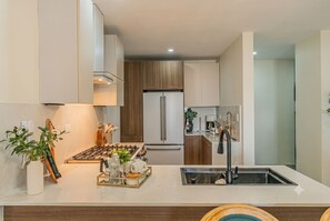 A modern kitchen with a stainless steel sink, a built-in oven, and a refrigerator. - 2 - bedroom skyline Oasis Over Santo Domingo DR (Santo Domingo)