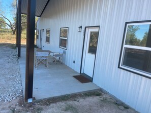 A building with a covered outdoor area, a door with a number, and a window. - New horse property  3 bed duplex with central heat and air near Stephenville (Stephenville)