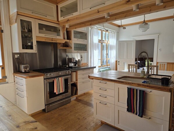 Una cocina con armarios de madera, una estufa y un lavabo.