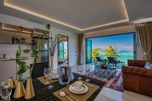 Un comedor moderno con una mesa dispuesta para dos personas, vistas al exterior y un balcón con asientos.