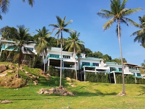 A multi-story building with a modern design, surrounded by palm trees and a grassy area. - Saengsuree Villas Koh Yao Yai (Koh Yao)