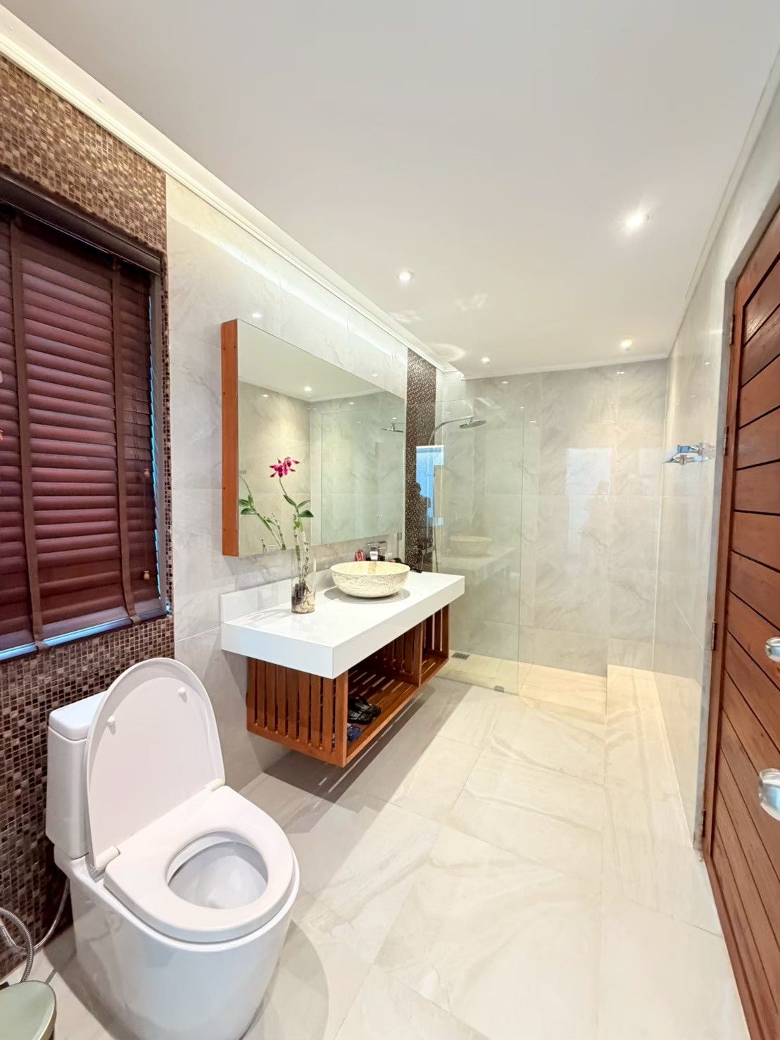 A modern bathroom with a toilet, a sink, and a shower area.
