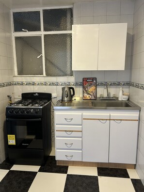 A kitchen with a gas stove, a coffee maker, and a sink. - New Listing (Bogotá)