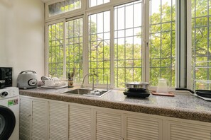 A kitchen with a large window, a washing machine, and a toaster. - OH Trendy homes Hoan Kiem LTT - City view duplex (Cua Nam)