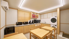 A modern kitchen with built-in appliances, wooden cabinetry, and a dining area. - Cheongdamjae by Anook Gwangju Sangmu (Gwangju)