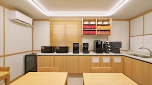 Cozinha compacta com micro-ondas, cafeteira e geladeira.
