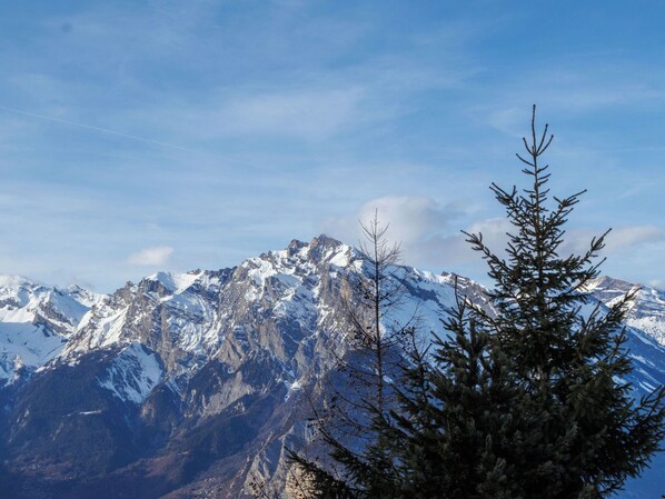 Paisaje montañoso con picos nevados y cielo despejado.