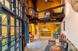 A spacious interior with a high ceiling, a staircase, and a dining area with stools. - Flow House 3BR Beachside An Bang Beach Hoi An by Beachside Boutique Homes (Đà Nẵng)