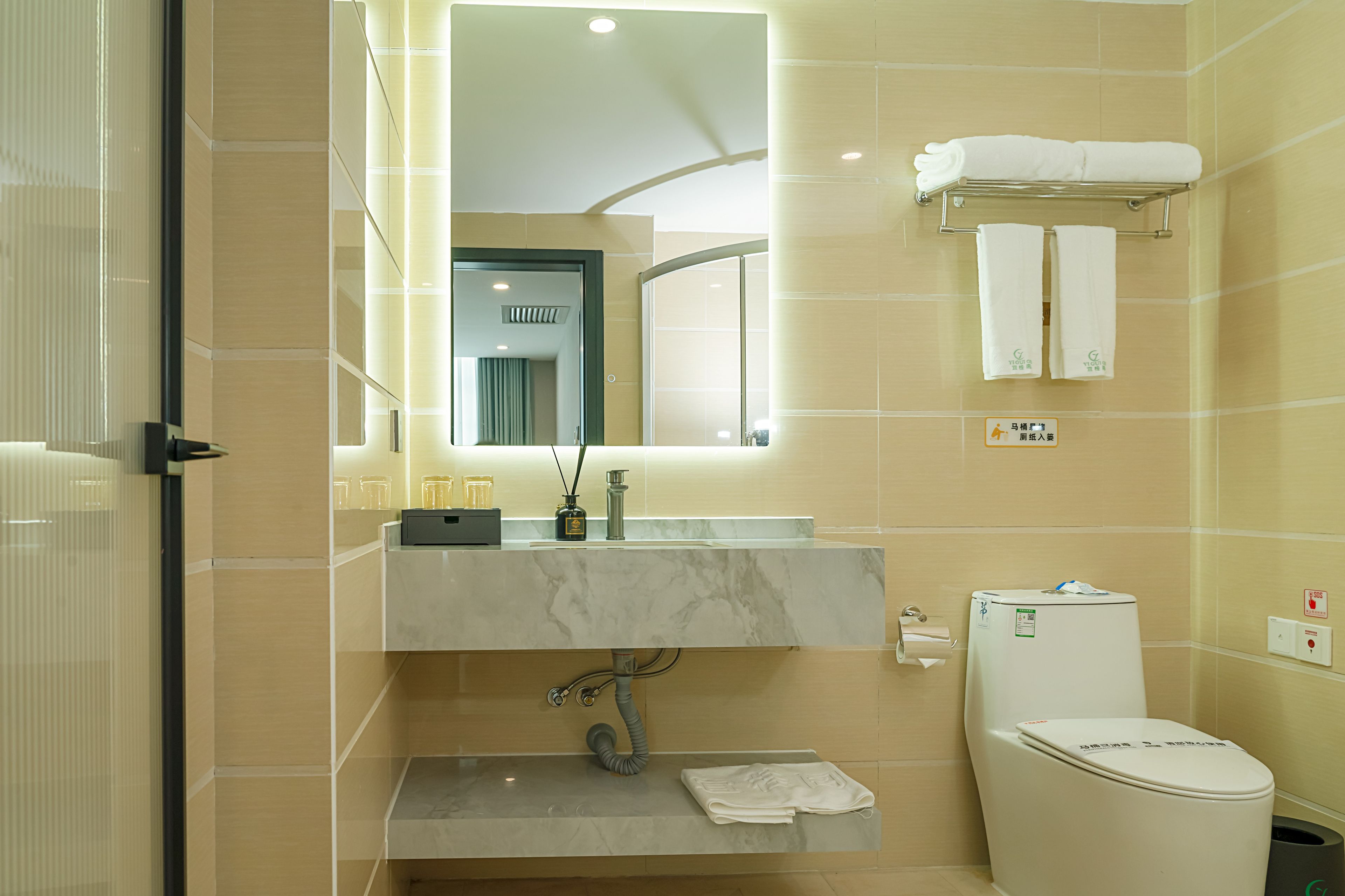 Une salle de bain moderne avec un lavabo en marbre, des toilettes et un miroir.