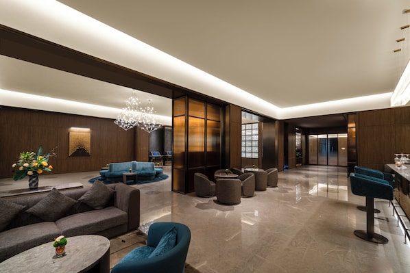 A modern hotel lobby with a seating area, a bar, and a chandelier. - Crystal Orange Hotel (Wuhan)