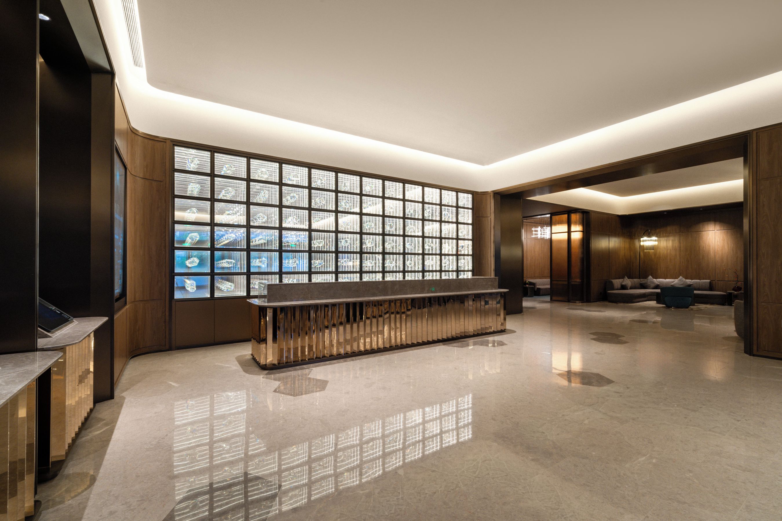 Una hall moderna con una reception, una parete vetrata ampia e un'area relax con divani.