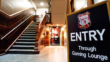 A sign indicating entry through the gaming lounge of the Union Jack Hotel.