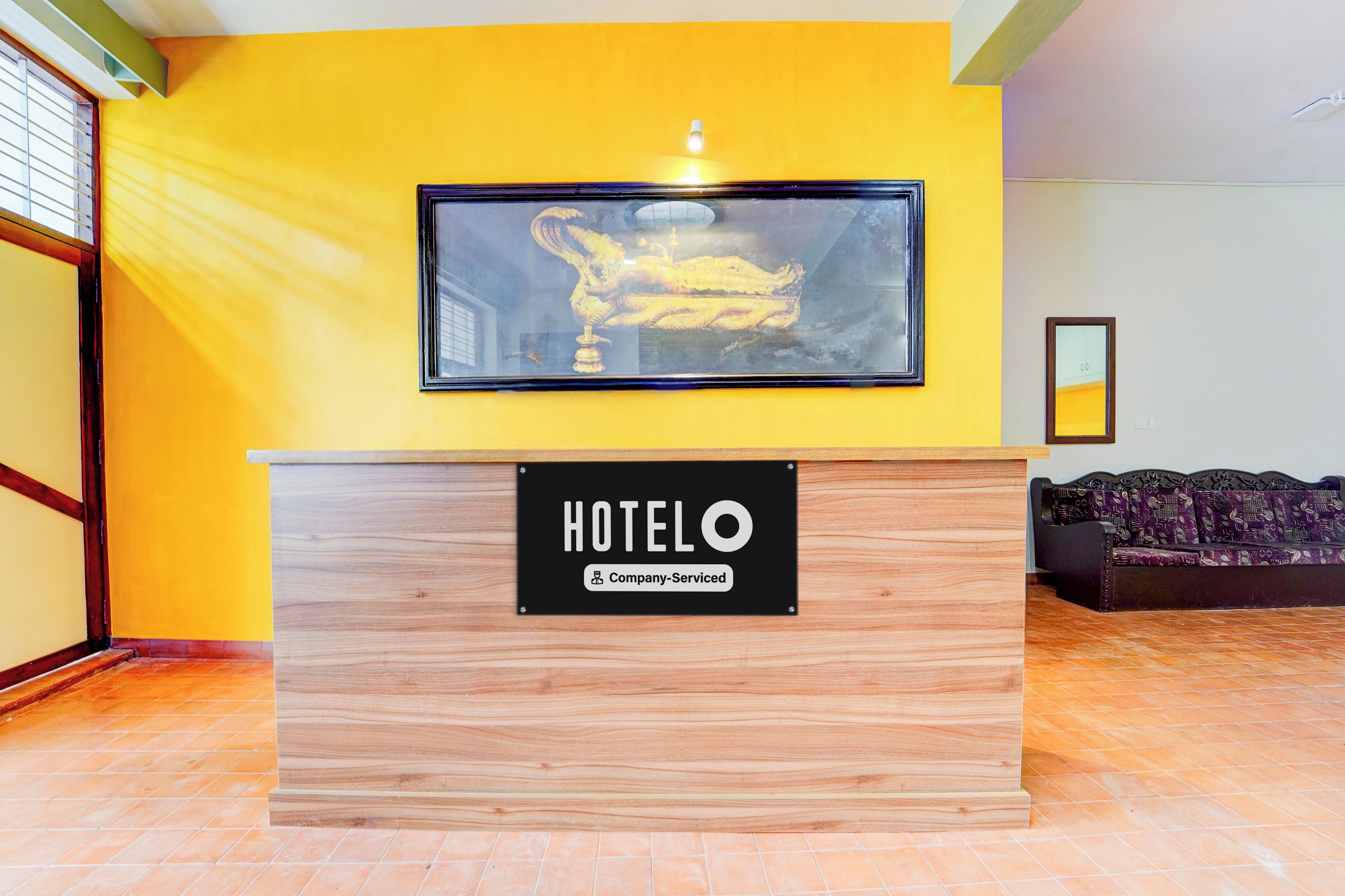 Una recepción de hotel con una obra enmarcada encima.