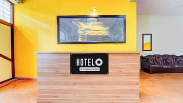 Una recepción de hotel con una obra enmarcada encima.