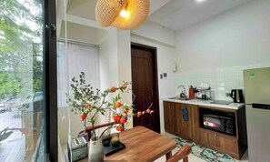 A modern kitchen with a wooden countertop, a built-in oven, and a dining area with a table and chairs. - OH Trendy homes Hoan Kiem LTK - Balcony City VIew (Cua Nam)