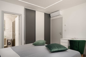 A modern bedroom with a bed, a bedside table, a green chair, and a wardrobe. - Villa Sanja (100711-K1) - Vizinada (Porec) (Vizinada (Porec))