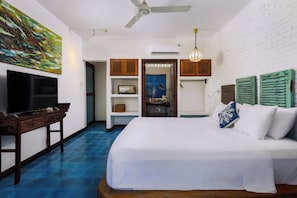 A hotel room with a bed, a TV, a desk, and a painting on the wall. - Loft House 2BR An Bang Beach Hoi An by Beachside Boutique Homes (Đà Nẵng)