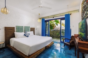 Ein Hotelzimmer mit Bett, Schreibtisch und Blick ins Freie.