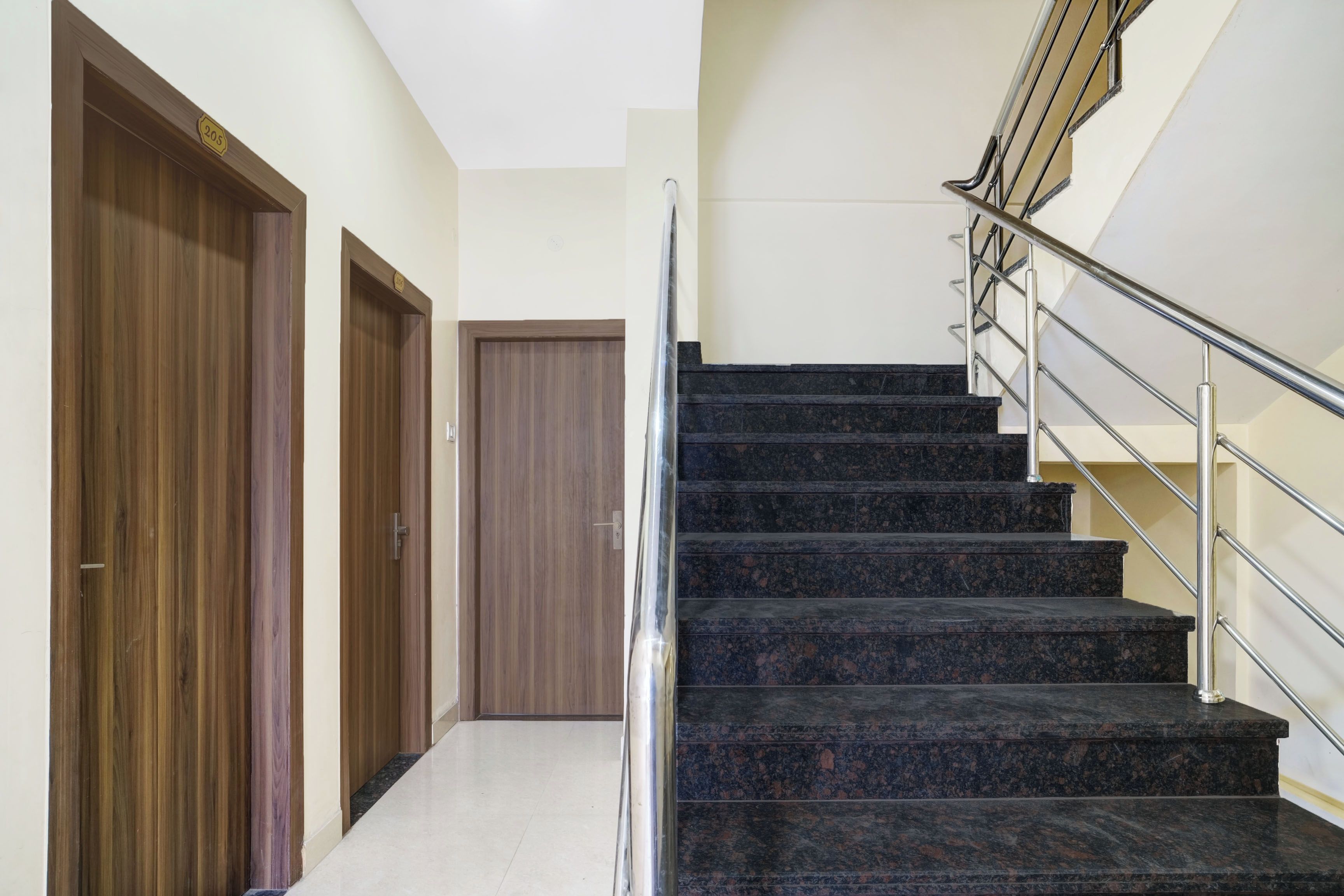 Un escalier avec des rampes métalliques menant à un palier.
