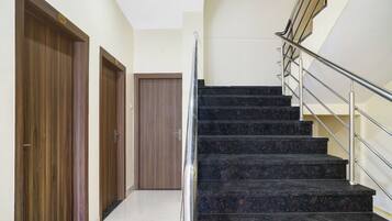 Un escalier avec des rampes métalliques menant à un palier.