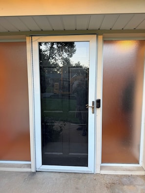 A sliding glass door with a metal handle and a white frame.