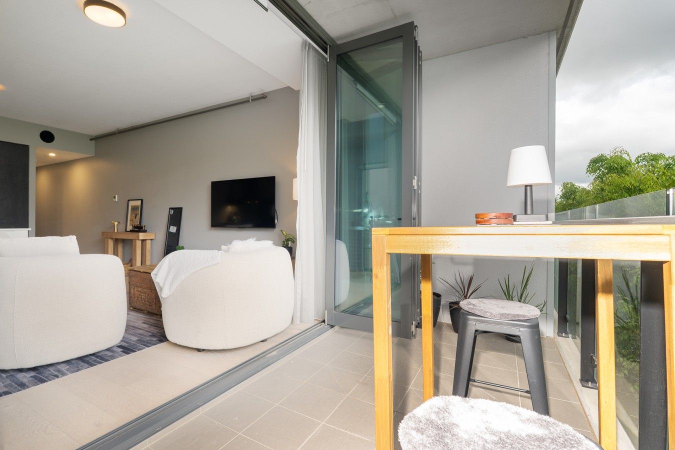 A modern bedroom with a bed, a bedside table, and a television.