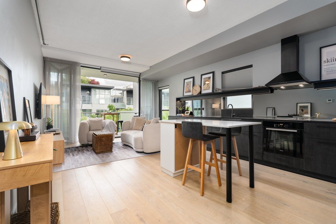 A modern kitchen with a central island, bar stools, and a built-in oven.