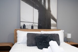 A hotel room with a large bed, two pillows, a nightstand with a lamp, and a cityscape view of a bridge. - Kingston 1BR in a Central Foreshore Location (Canberra (Inner South))