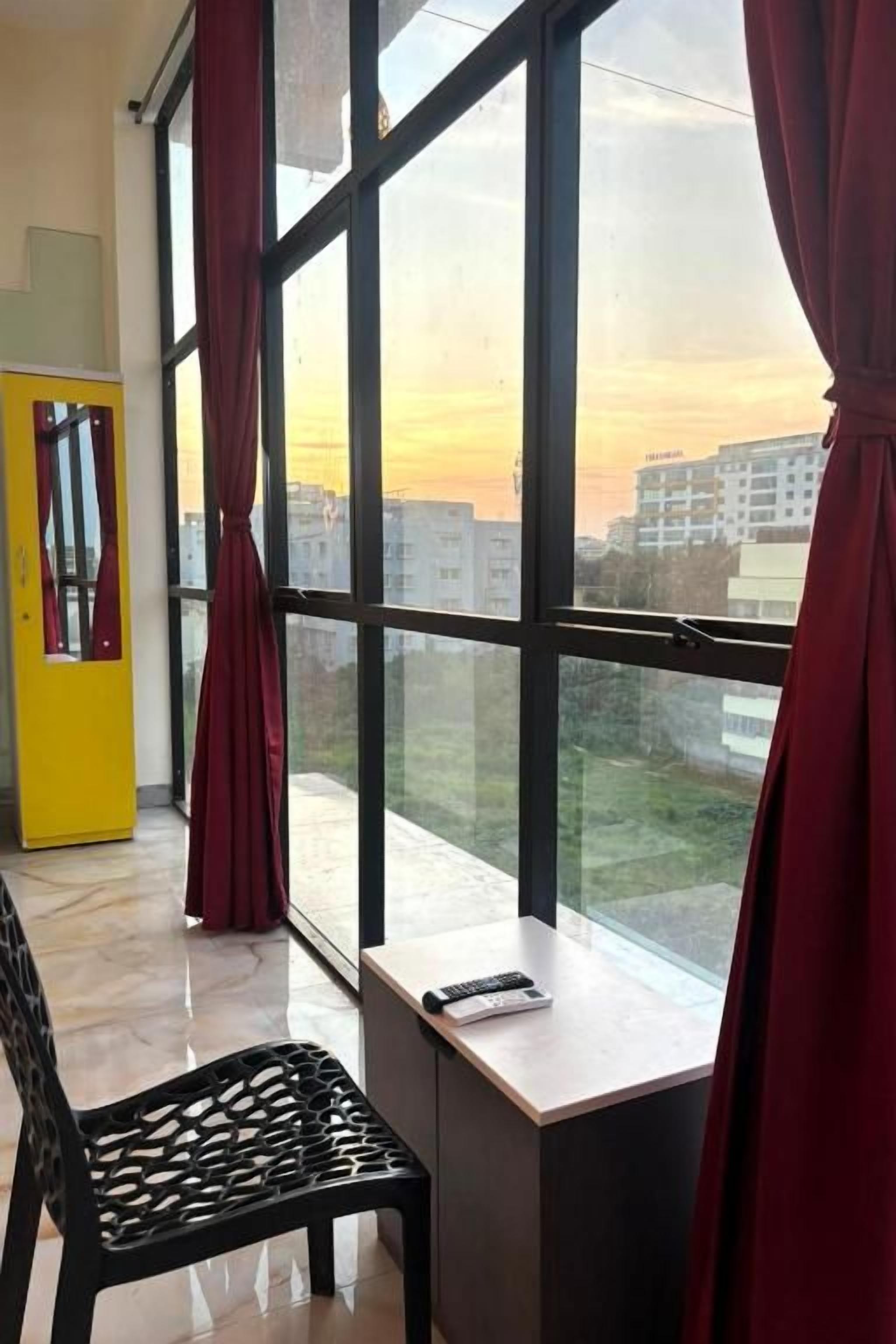 A room with a large window, a desk, and a chair.
