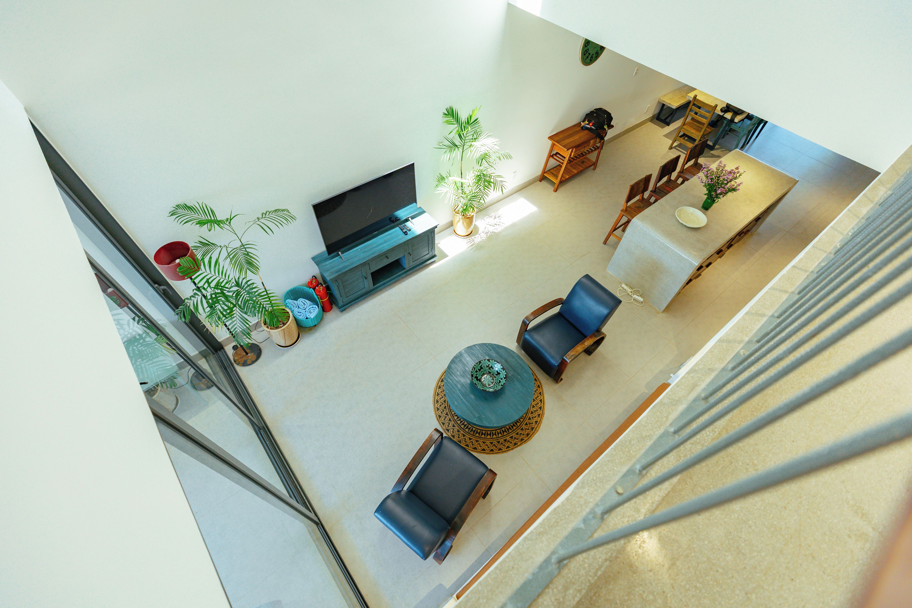 Een ruime woonkamer met een flatscreen-tv, zitgedeelte en potplanten.