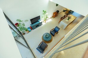 A spacious living area with a flat-screen TV, seating arrangements, and potted plants. - Sunrise Villa 4BR Tan Thanh Beachside by Beachside Boutique Homes (Đà Nẵng)