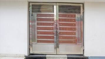 Una puerta doble con barrotes horizontales de metal y un picaporte de metal.