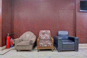 Three chairs in a room with a wooden wall and a fire extinguisher.