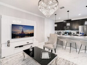A modern kitchen with dark cabinets, stainless steel appliances, and a bar area with white bar stools. - Golf Themed 4BR · Private Pool · ChampionsGate (Davenport)