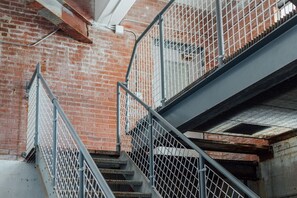 Un escalier en métal avec un mur de briques en arrière-plan.