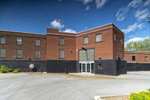 A brick building with a large glass entrance and a black wall to the left. - Wall Street Suites 1 | King Suite near SIU with Kitchen (Carbondale)